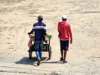 Rear view of people walking on road