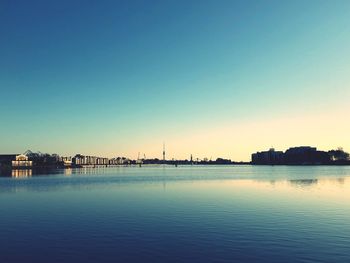 Scenic view of lake against clear sky during sunset