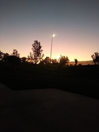 Silhouette trees against clear sky during sunset