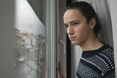 Thoughtful man looking through window