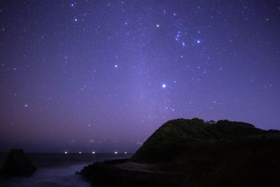 Scenic view of sea against star field at night