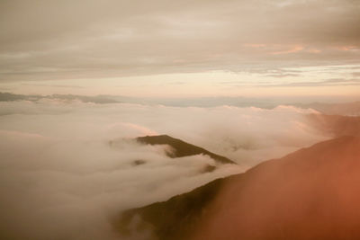 Aerial view of majestic mountains against sky during sunset