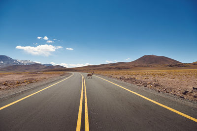 Scenic view of mountains in desert with country road against clear sky