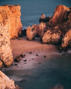 Rock formations by sea against sky