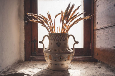 Close-up of vase against wall at home