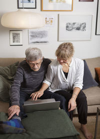 Couple using laptop on sofa