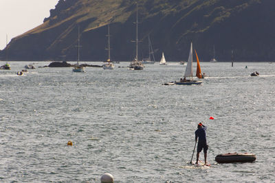 People on beach by sea against sky