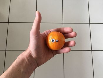 Close-up of hand holding orange