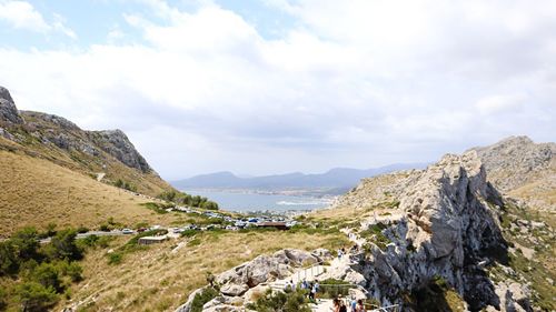 Scenic view of mountains by sea against sky