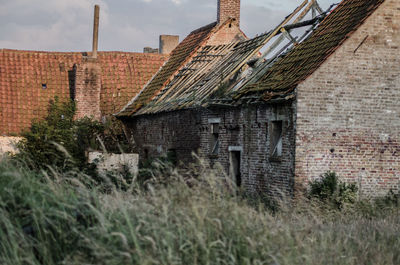 Abandoned house roof against sky