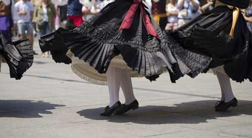 Low section of people traditional dancing on street in city