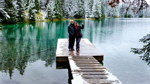 Man standing by lake against trees