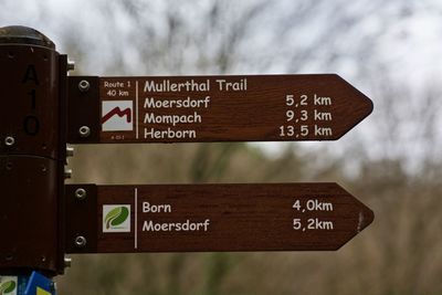 Close-up of road sign against sky