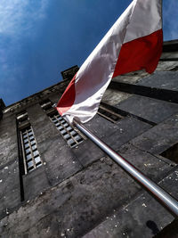 Low angle view of flag against sky in city