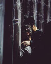 Full length portrait of woman sitting in dark room
