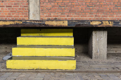 Yellow steps under red brick wall