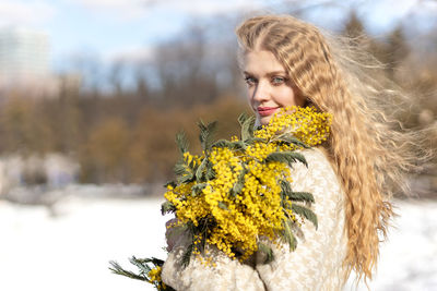 A woman with a bouquet of yellow acacia flowers. spring holiday - march 8, easter, women's day