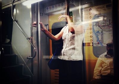 Woman and man in subway train seen from window