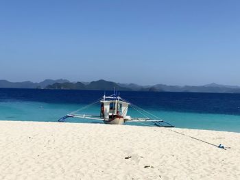 Fishing boat on beach against sky