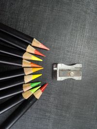 Directly above shot of colored pencils and sharpener on table