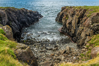Rock formations by sea against sky