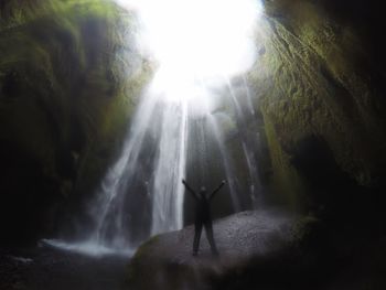 Low angle view of waterfall in forest against sky