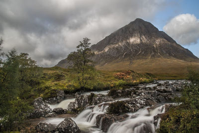 Scenic view of waterfall against sky