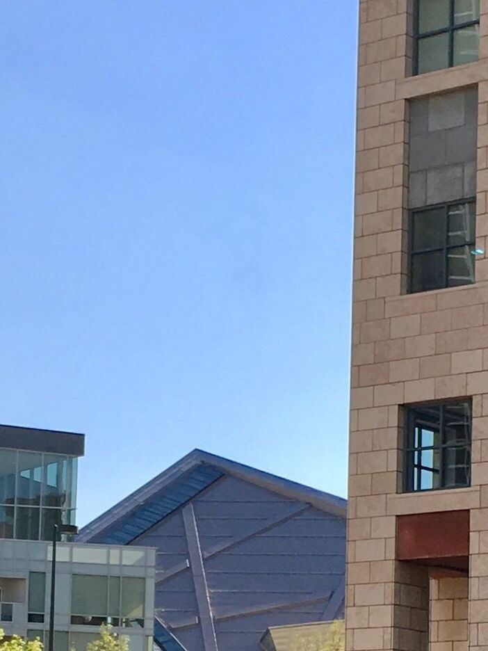 LOW ANGLE VIEW OF OFFICE BUILDING AGAINST BLUE SKY