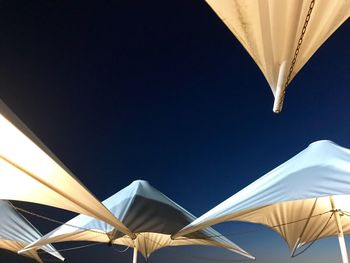 Low angle view of umbrella against clear blue sky