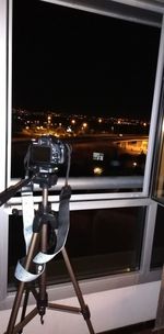 Close-up of illuminated lamp post through window at night