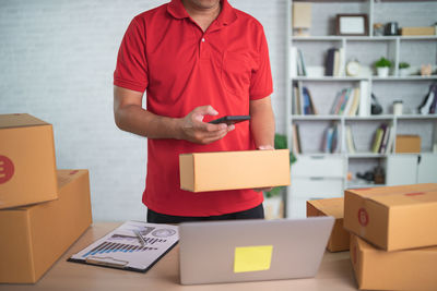 Midsection of man holding box