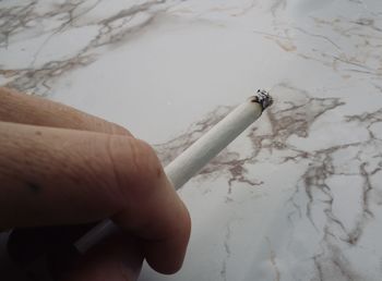 Cropped image of hand holding cigarette