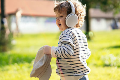 Cute boy wearing headphones walking outdoors