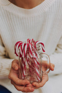 Midsection of woman holding candy canes