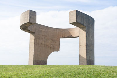 Low angle view of a monument on field against sky