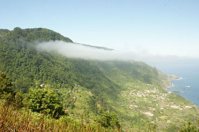 Scenic view of sea and mountains against sky