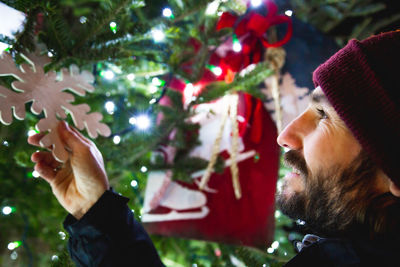 Close-up of man touching christmas decoration