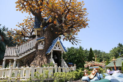 Man by tree against clear sky