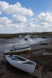 Boat moored on beach against sky