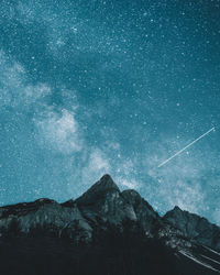 Scenic view of mountains against blue sky at night