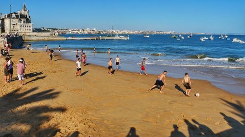 People on beach against clear sky