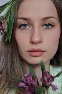 Close-up portrait of young woman with flowers