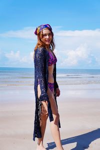 Full length of young woman at beach against sky
