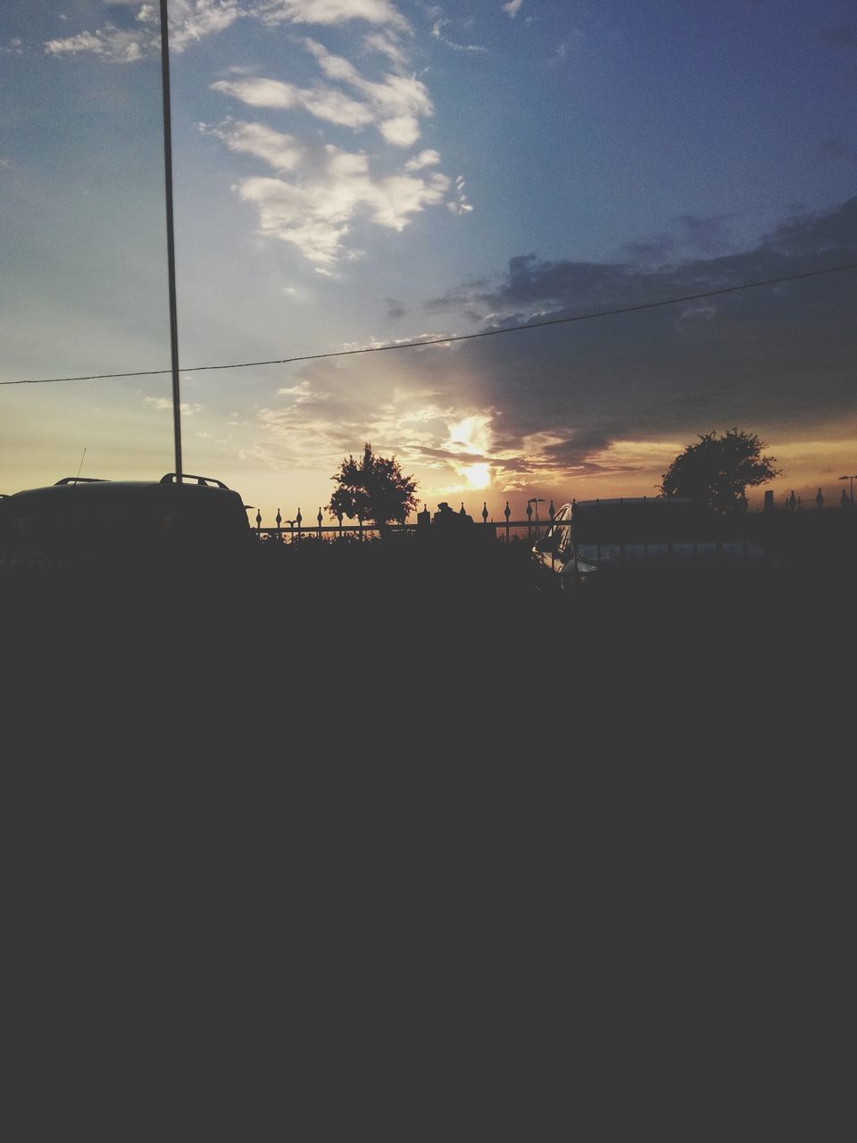 sunset, silhouette, sky, tree, tranquility, scenics, tranquil scene, cloud - sky, beauty in nature, power line, dark, nature, street light, electricity pylon, orange color, cloud, sunlight, dusk, no people, outdoors