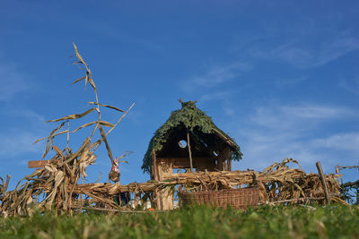 Traditional windmill on field against blue sky