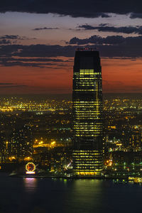 Illuminated buildings against sky during sunset