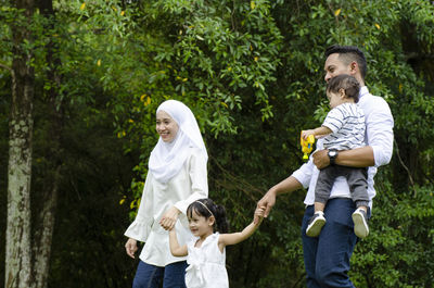 Full length of father with daughter against trees