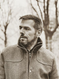 Portrait of young man standing against trees