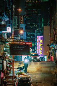 Cars on illuminated city street at night