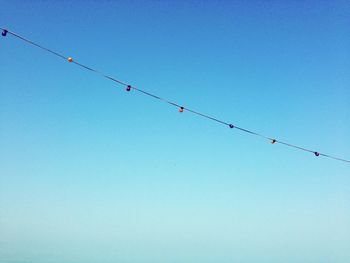 Low angle view of cables against clear blue sky